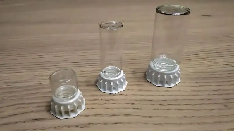 Three liquid feeders with glass bottles on white 3D-printed bases, ready to hold water or sugar water
