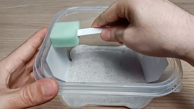 Brushing escape prevention oil with a sponge applicator along the inner walls of a plastic tub outworld